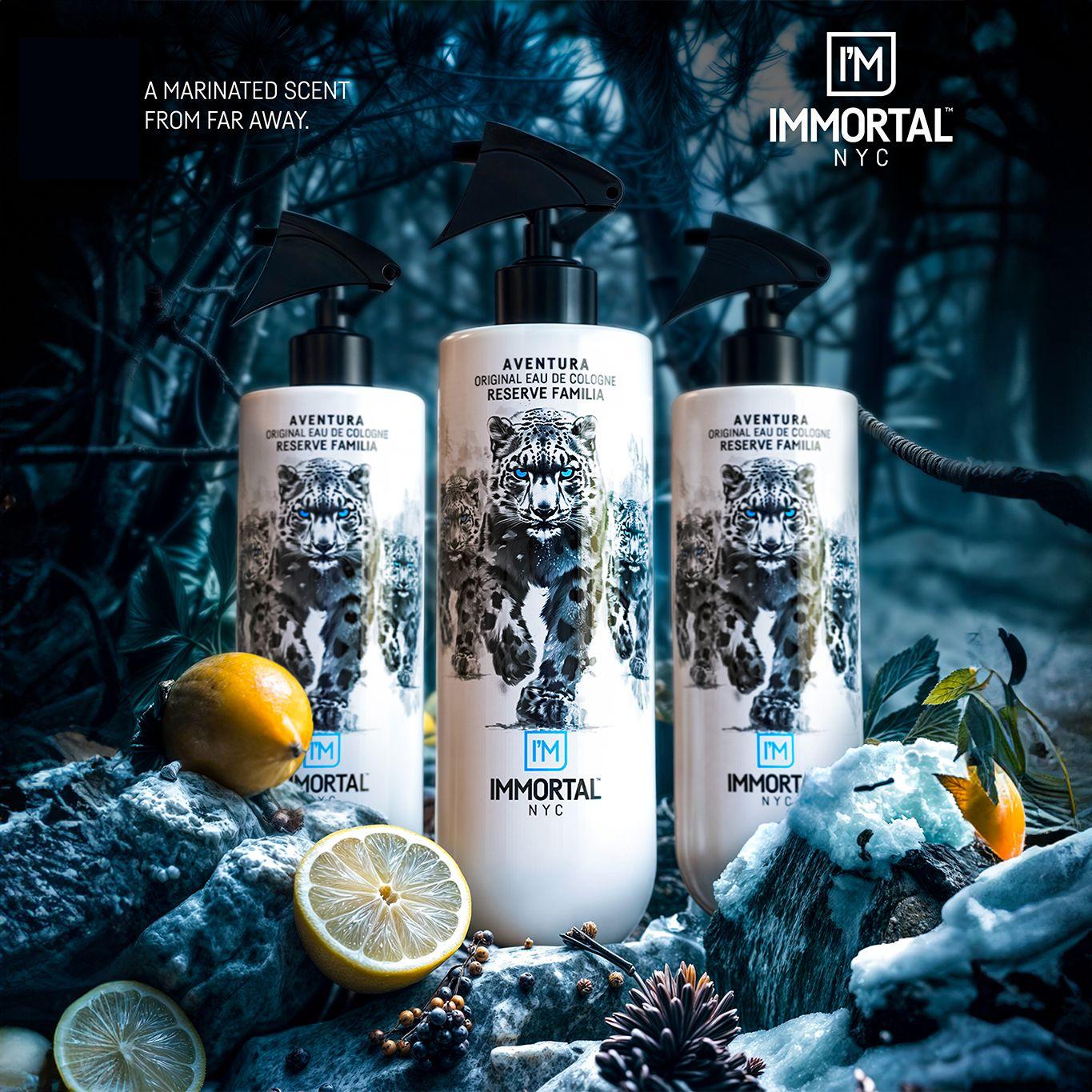 Three bottles of Immortal NYC perfume on a textured surface with lemons and leaves.