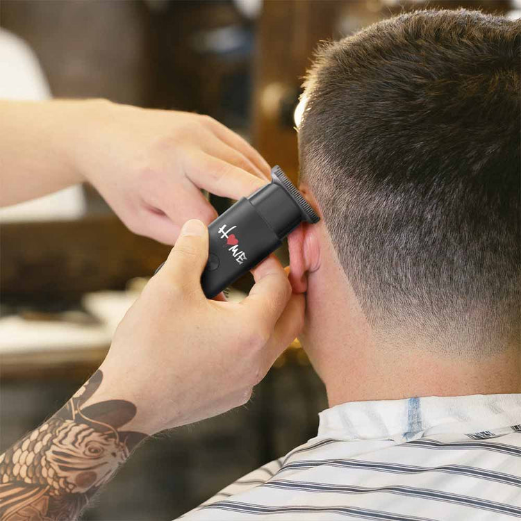 barber giving haircut to man using trimmer