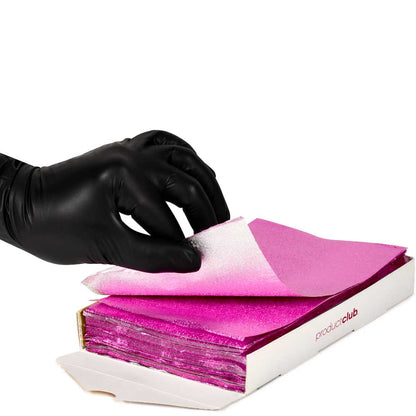 A hand wearing a black nitrile glove lifts a sheet of sparkling hot pink cosmetic powder from an open white box labeled 'productclub' on a white background.