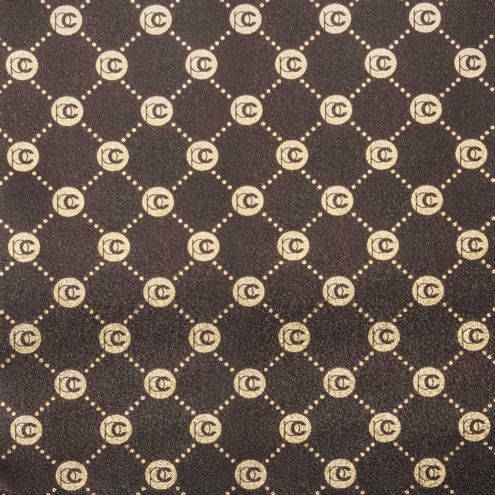 Dark brown textured fabric with a repeating gold monogram pattern of interlocking PC circles connected by dotted lines.