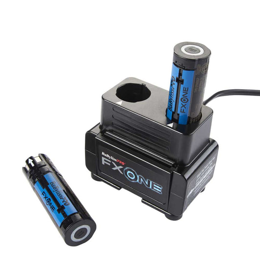 A black FX ONE dual battery charger with two cylindrical batteries, one inserted into the charging port and one placed beside it, on a white background.