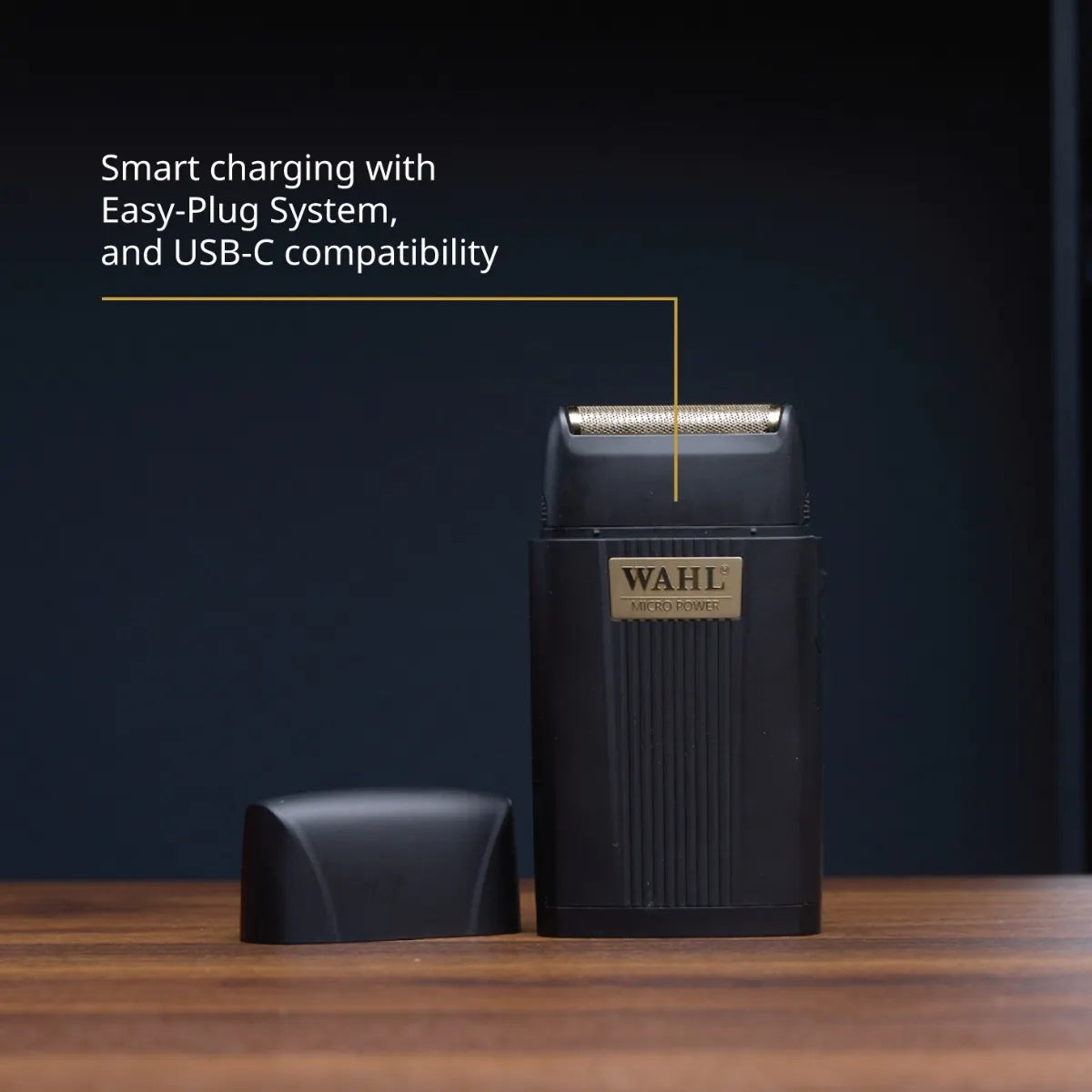 Black Wahl electric shaver on a wooden surface with a dark blue background