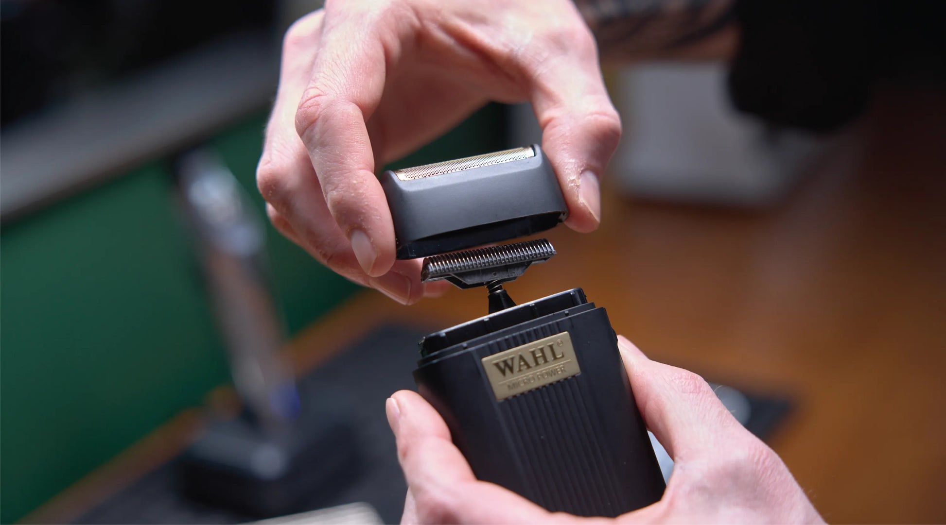 Person holding a Wahl electric shaver with a blurred background
