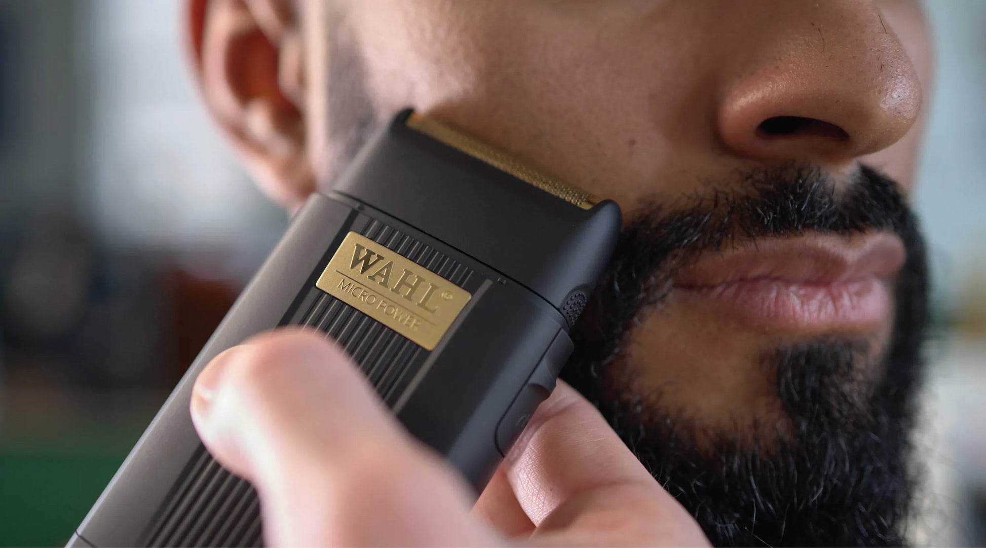Person using a Wahl electric razor on their beard
