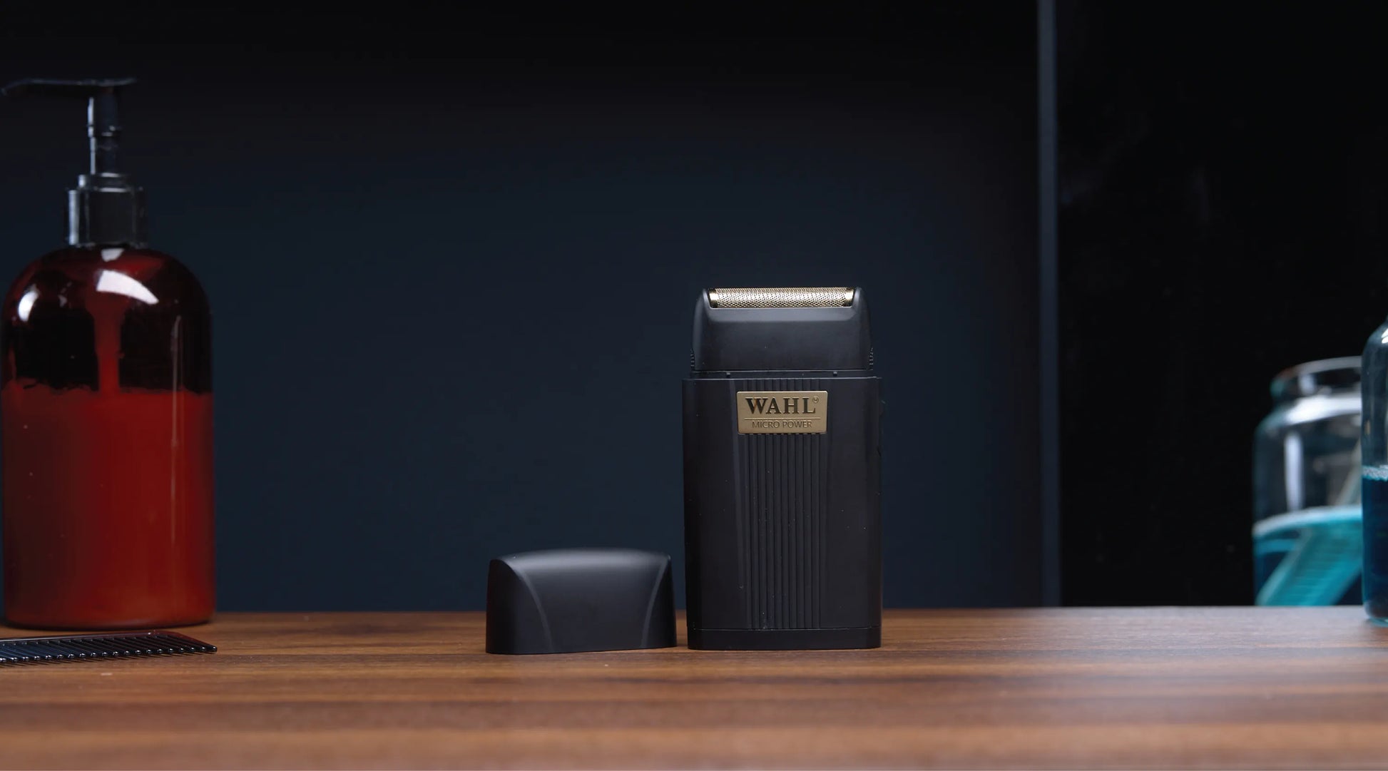 Black Wabi shaving device on a wooden surface with a dark background